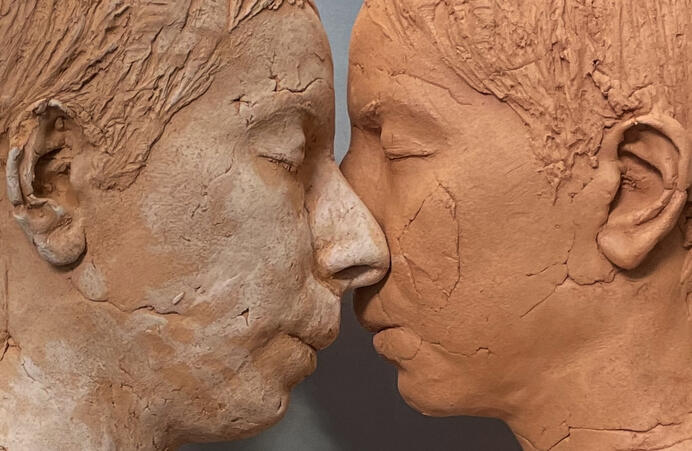 color photo of two sculptural faces by Roskana Pirouzmand, facing each other so their noses touch